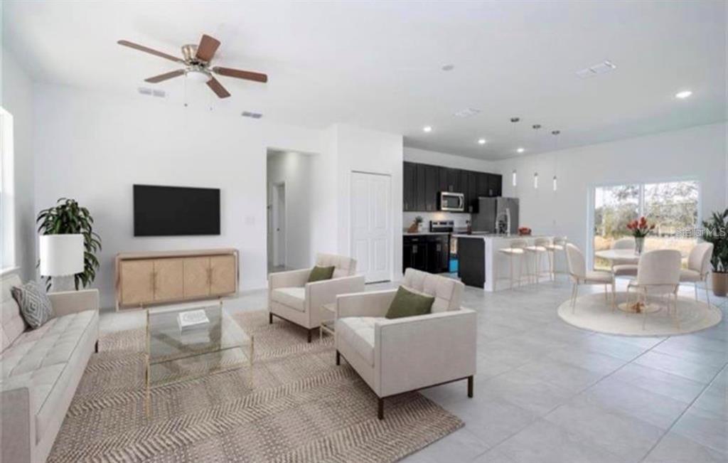 An open-concept living room and kitchen featuring white walls, tile flooring, and modern furniture — 267 MARION OAKS GOLF ROAD, OCALA, FL