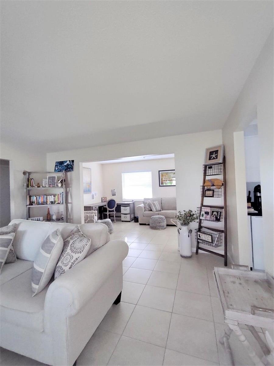 A living room with white tile floors leads into an adjacent office and seating area — 1826 SW Congress Boulevard, Boynton Beach FL 33426, BOYNTON BEACH, FL
