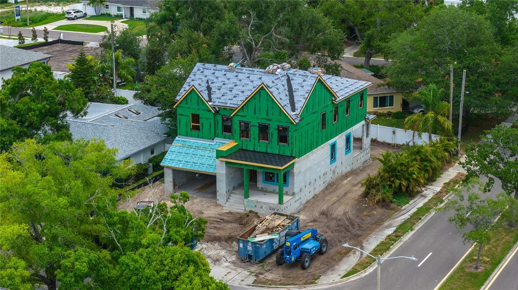 An aerial view shows a two-story house under construction with green exterior sheathing and roofing underlayment — 3420 S GARDENIA AVENUE, TAMPA, FL