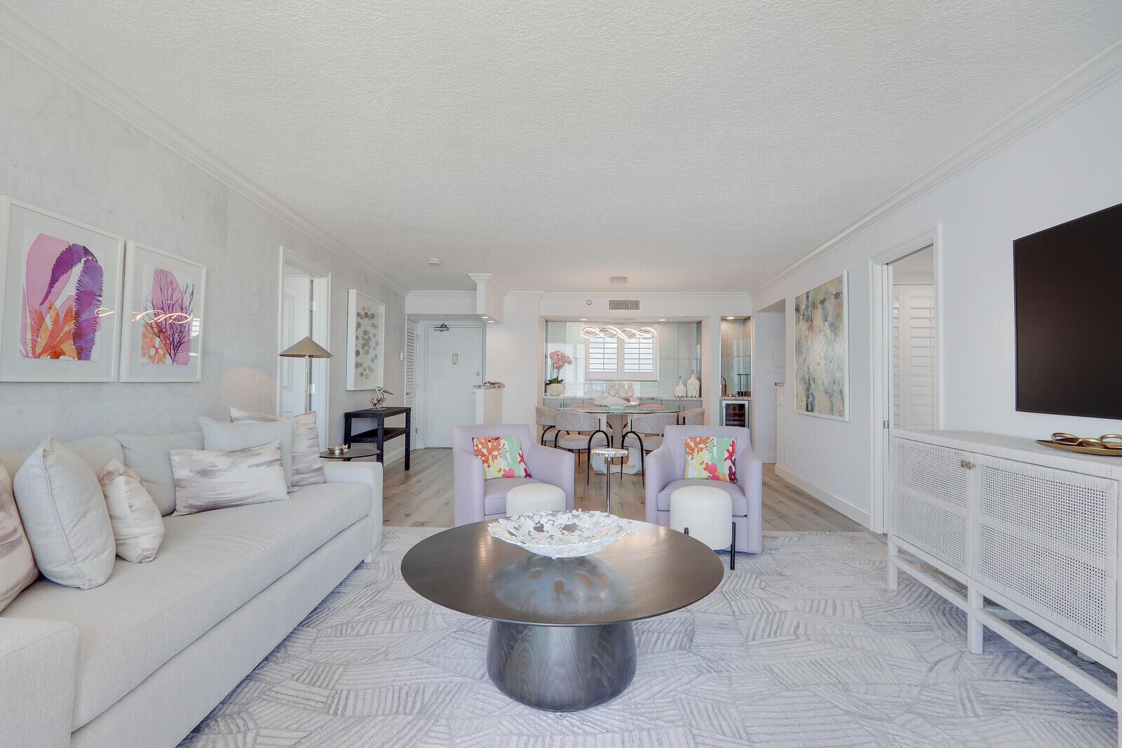 A bright living room features a light gray sofa, two armchairs, and a round coffee table — 100 Ocean Trail Way, Jupiter FL 33477, JUPITER, FL