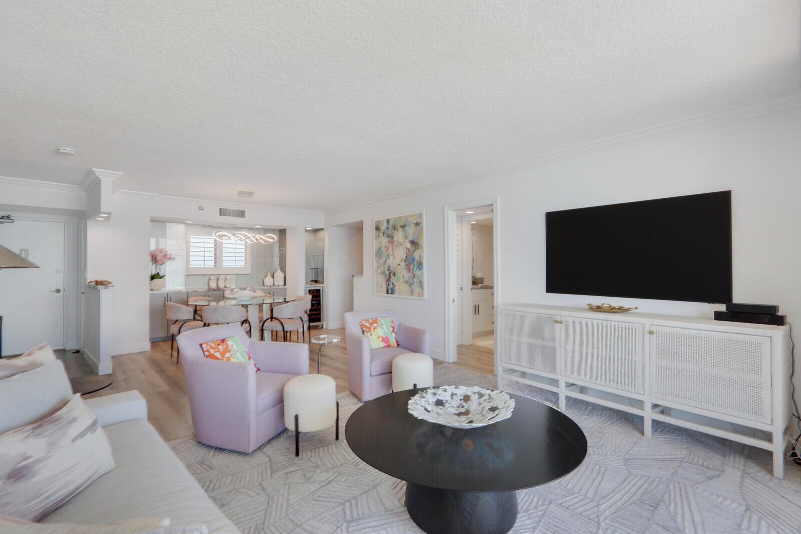 A living room with a black coffee table, two lavender armchairs, and a white media console — 100 Ocean Trail Way, Jupiter FL 33477, JUPITER, FL