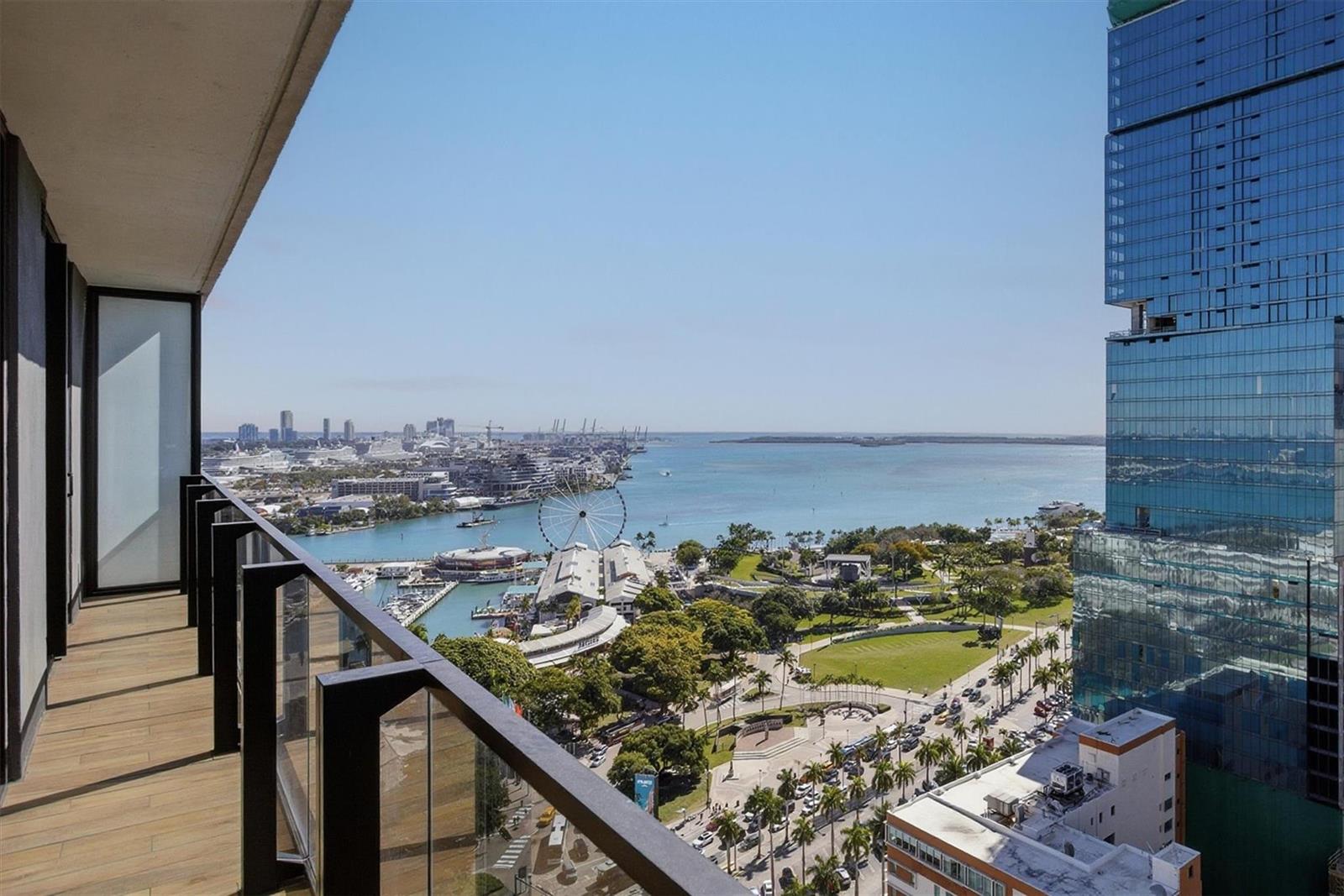 A high-rise balcony overlooks a city park, a Ferris wheel, and a harbor with ships — 398 NE 5th Street # 2017, Miami FL 33132, MIAMI, FL