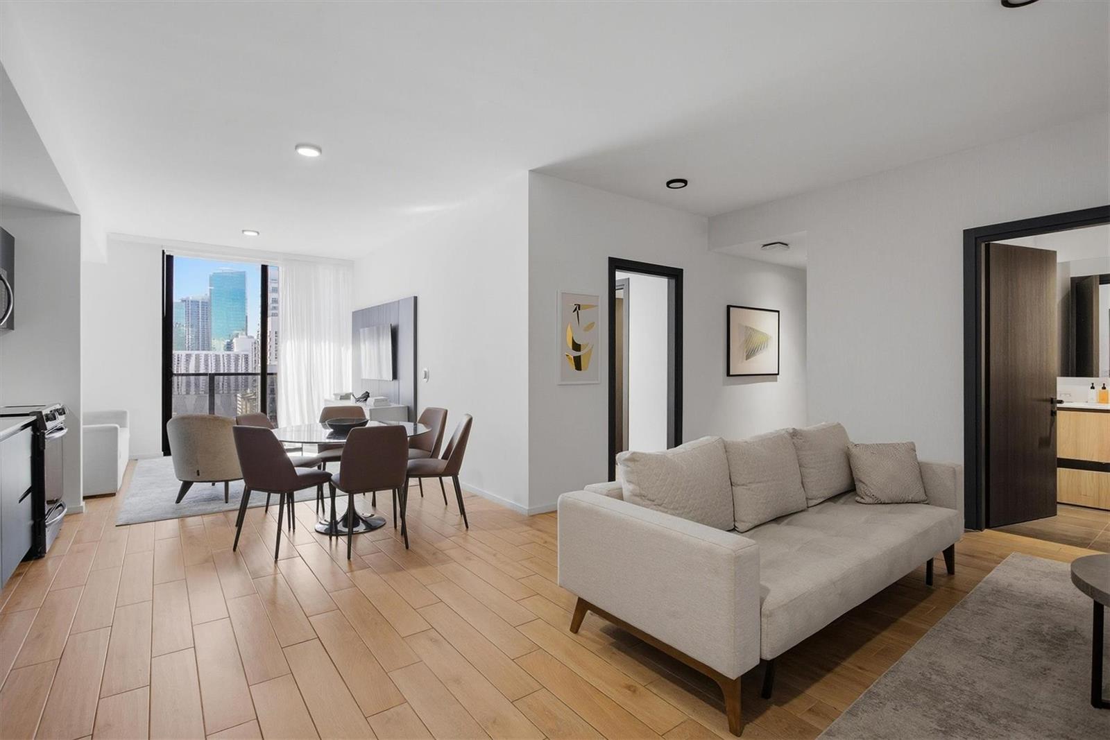 A modern living room and dining area with light wood floors and city views — 398 NE 5th Street # 2017, Miami FL 33132, MIAMI, FL