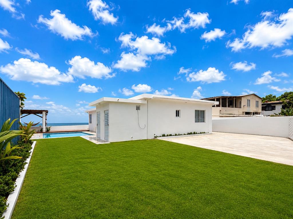 A white house with a swimming pool and a green lawn under a blue sky — CARR 3 BO BAJOS VILLA PESQUERA, PATILLAS, PR