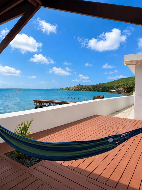 A wooden deck with a hammock overlooks the ocean and a distant shoreline — CARR 3 BO BAJOS VILLA PESQUERA, PATILLAS, PR
