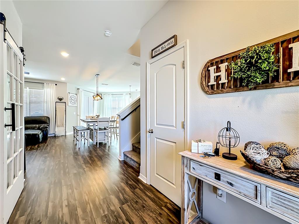 An entryway with wood-look flooring leads to a dining area and a staircase — 11205 BRIGHTON KNOLL LOOP, RIVERVIEW, FL