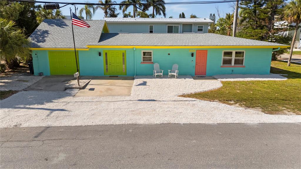 A single-story house with turquoise siding, a yellow trim, and a bright orange front door — 204 29TH STREET, HOLMES BEACH, FL