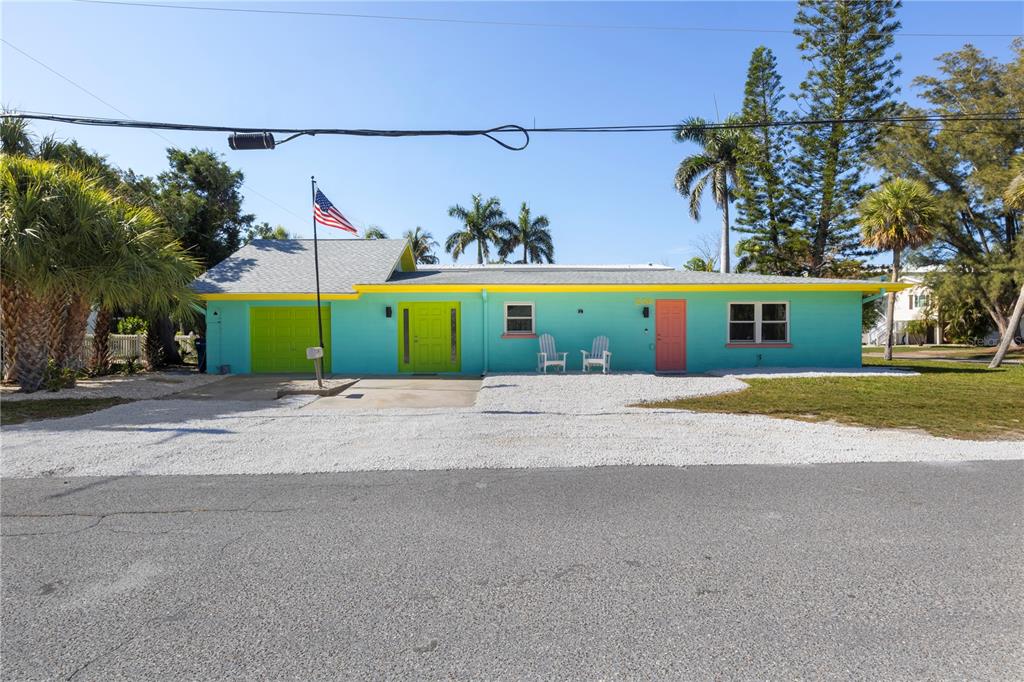 A single-story house with turquoise siding, a yellow roof trim, and a gravel driveway — 204 29TH STREET, HOLMES BEACH, FL