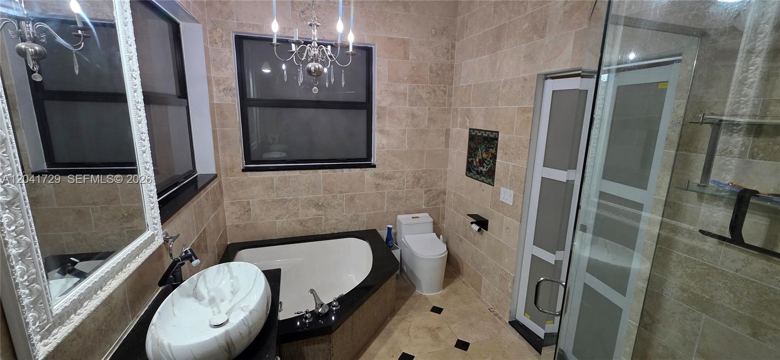 A bathroom features a corner soaking tub, a vessel sink, a toilet, and tiled walls — 5010 Perignon Way, Coral Springs FL 33067, CORAL SPRINGS, FL