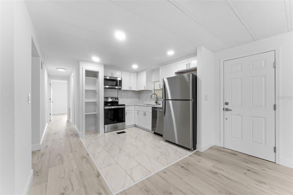 A kitchen with white cabinets, stainless steel appliances, and light-colored tile flooring — 130 FLORENCE BOULEVARD, DEBARY, FL