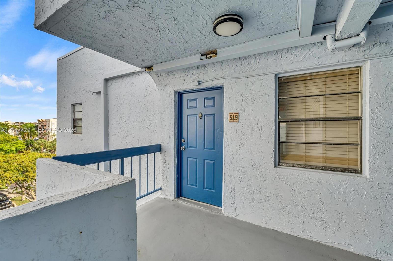 A blue front door with the number 519 is located on a concrete balcony — 9460 Fontainebleau Blvd # 519, Miami FL 33172, MIAMI, FL