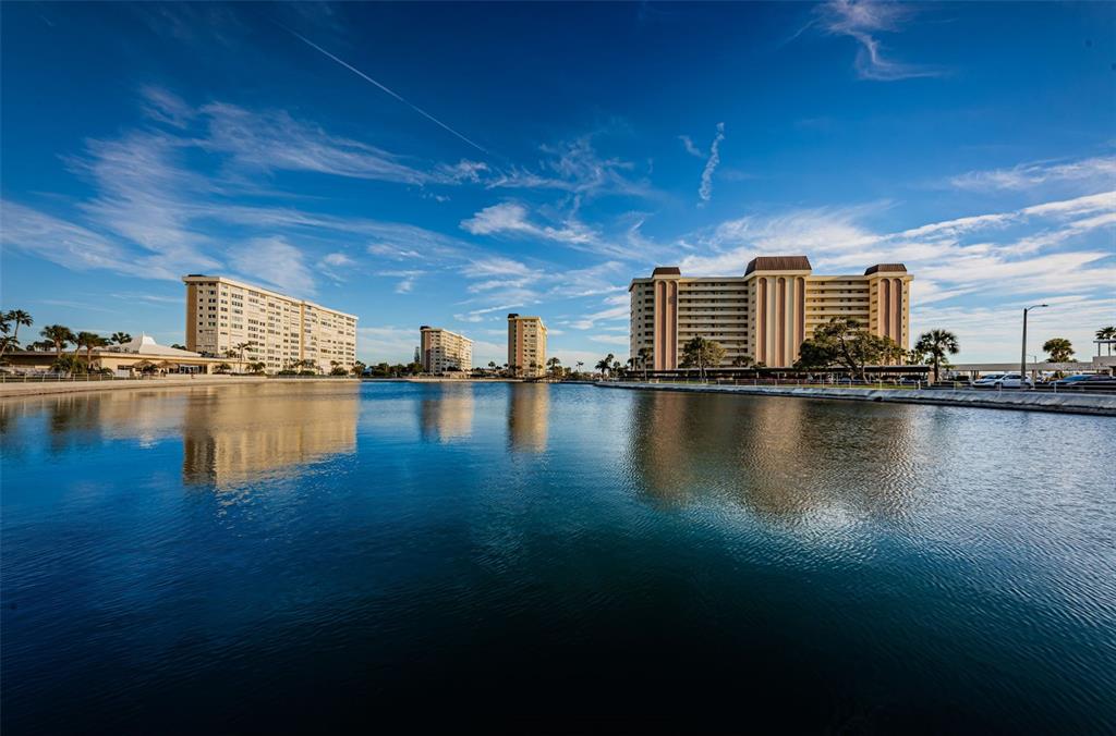 A view of several tall apartment buildings across a calm body of water — 4700 COVE CIRCLE UNIT 208, ST PETERSBURG, FL