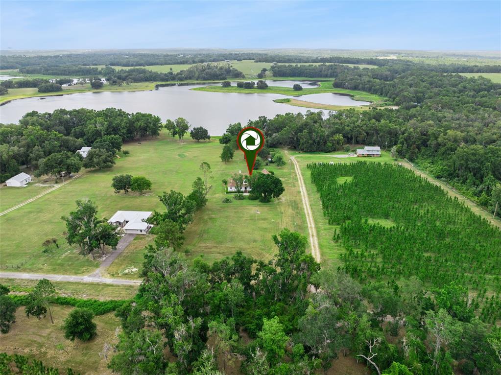 An aerial view shows a house on a large rural lot near a lake — 25895 TILLY HAWK LANE, BROOKSVILLE, FL