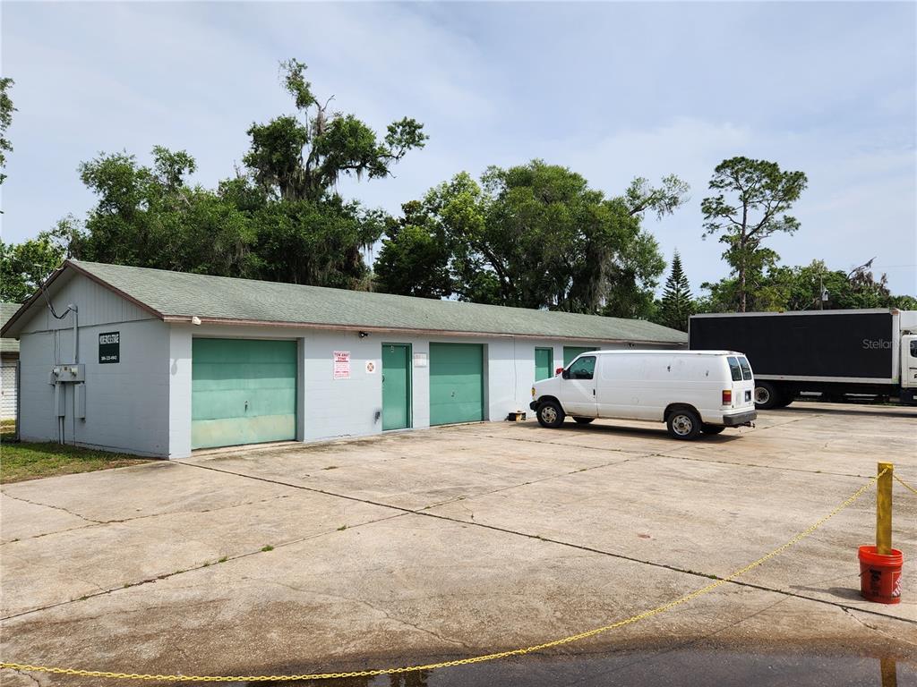 A single-story commercial building with green garage doors and a white van parked outside — 500 E COURT STREET, BUNNELL, FL