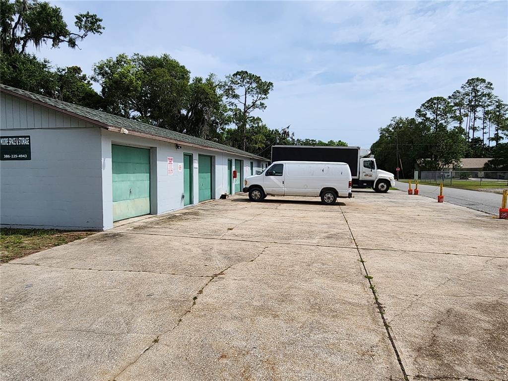 A single-story storage facility with multiple garage doors and a white van parked outside — 500 E COURT STREET, BUNNELL, FL