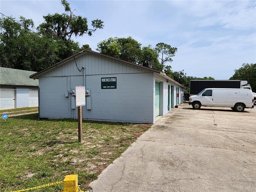 A gray, single-story storage building with multiple unit doors and a white van parked nearby — 500 E COURT STREET, BUNNELL, FL