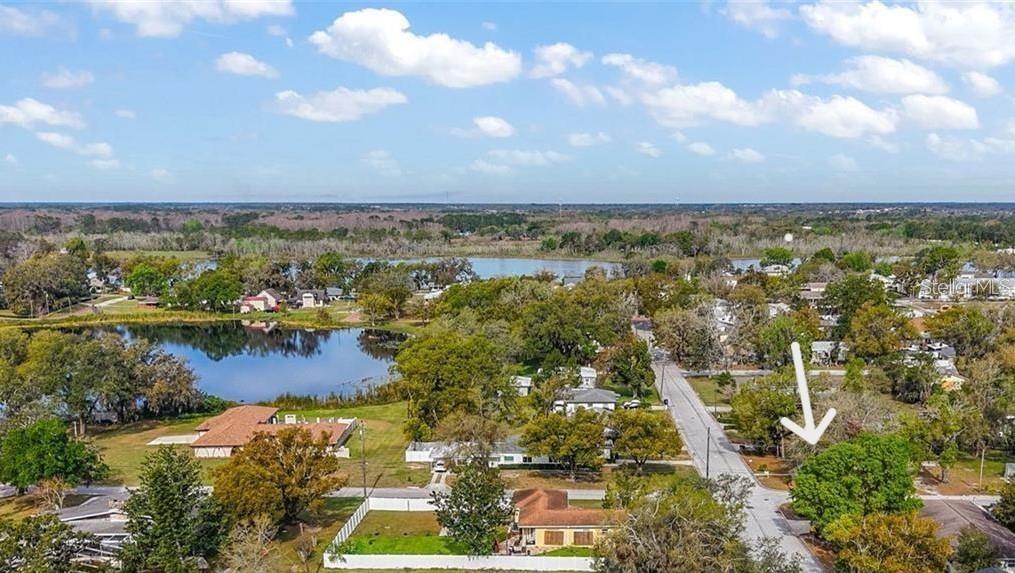 An aerial view shows a residential neighborhood with a lake and a marked property — 373 E WALDO STREET, GROVELAND, FL