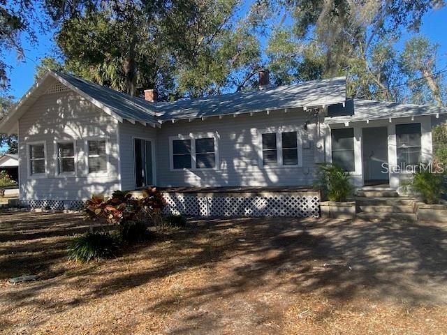 A light-colored, single-story house with a metal roof and a lattice-covered foundation — 373 E WALDO STREET, GROVELAND, FL