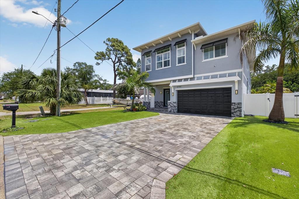 A two-story house with a gray exterior, a paved driveway, and a black garage door — 6706 S STERLING AVENUE, TAMPA, FL