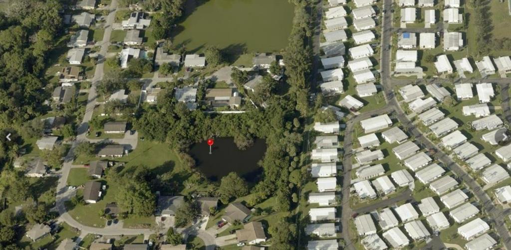 This aerial view shows a residential neighborhood with a pond marked by a red pin — ALGERIA COURT, BRADENTON, FL