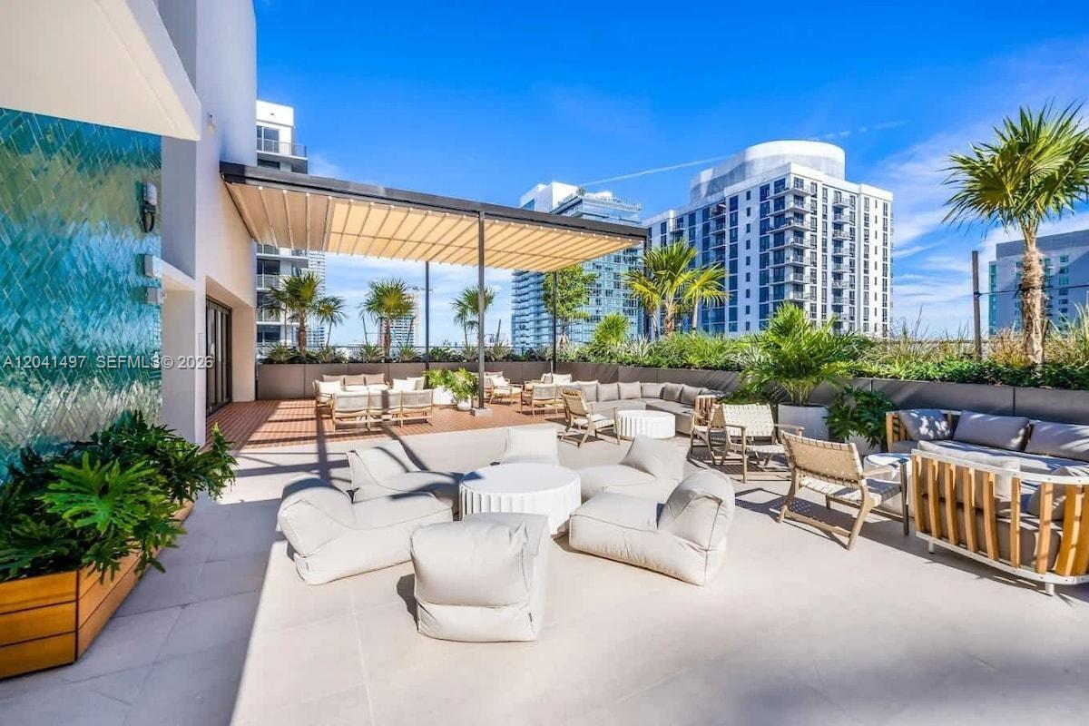 A spacious outdoor rooftop terrace features lounge seating, a retractable pergola, and city skyline views — 11 NE 6th St # 807, Miami FL 33132, MIAMI, FL