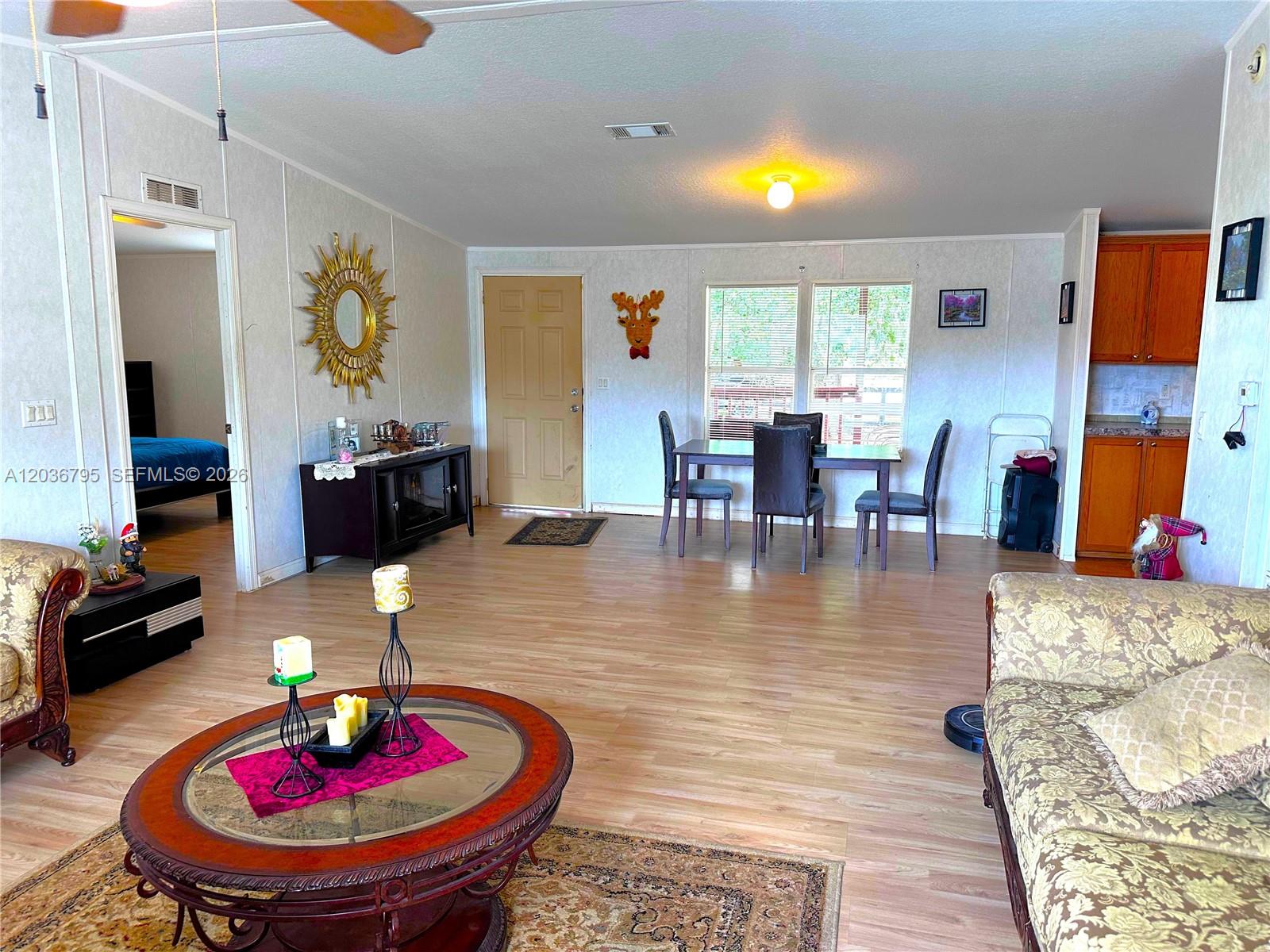 A living room and dining area feature light wood flooring, white walls, and wood cabinetry — 1 Ridge Rd, Frostproof FL 33843, FROSTPROOF, FL