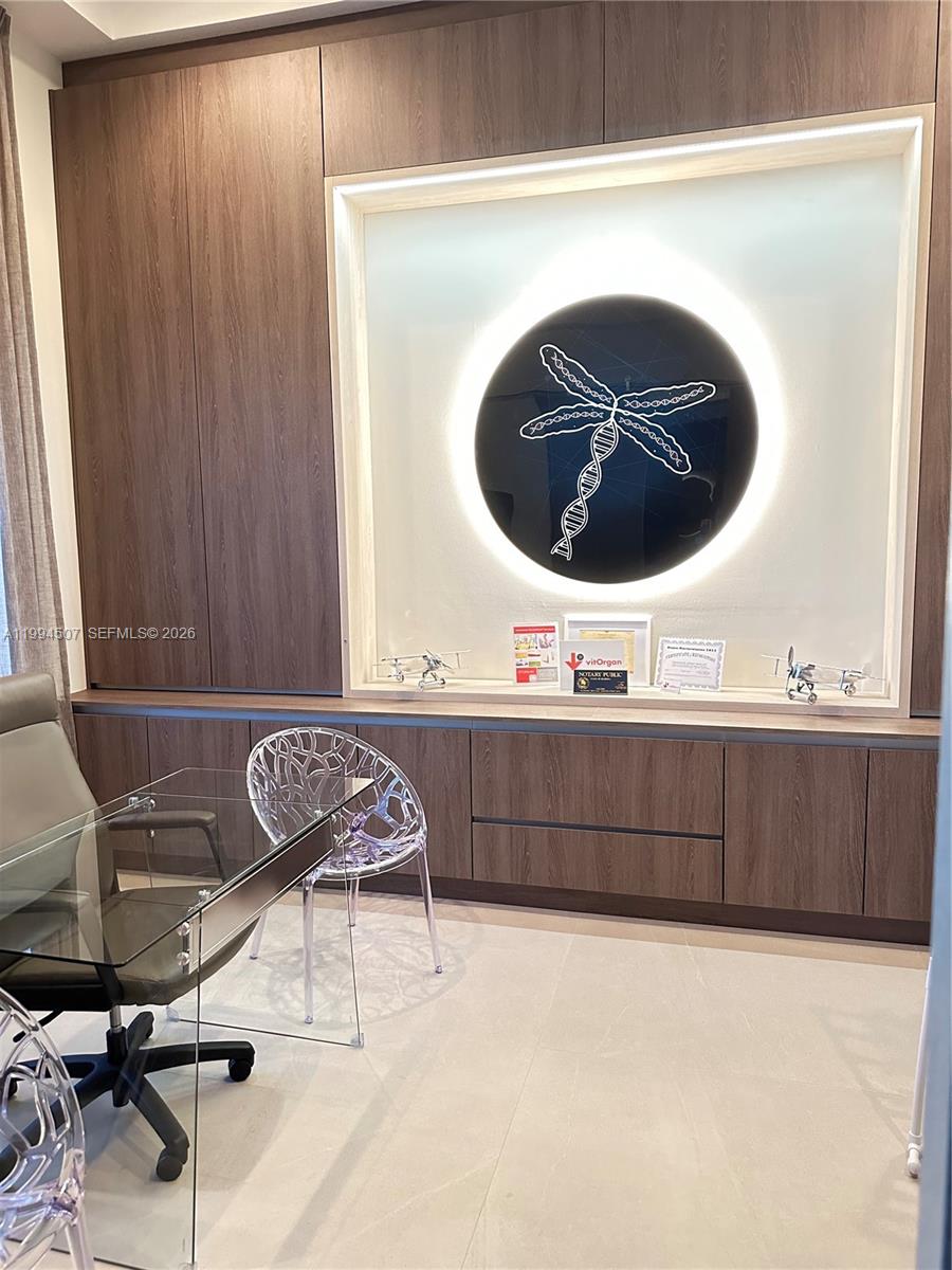 A modern office features a glass desk, patterned chairs, and a backlit circular wall art — 4896 Corrado Ave, Ave Maria FL 34142, AVE MARIA, FL