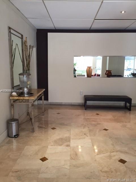 A lobby area features a marble floor, a console table with a water dispenser, and a bench — 150 SE 25 RD # 15F, Miami FL 33129, MIAMI, FL