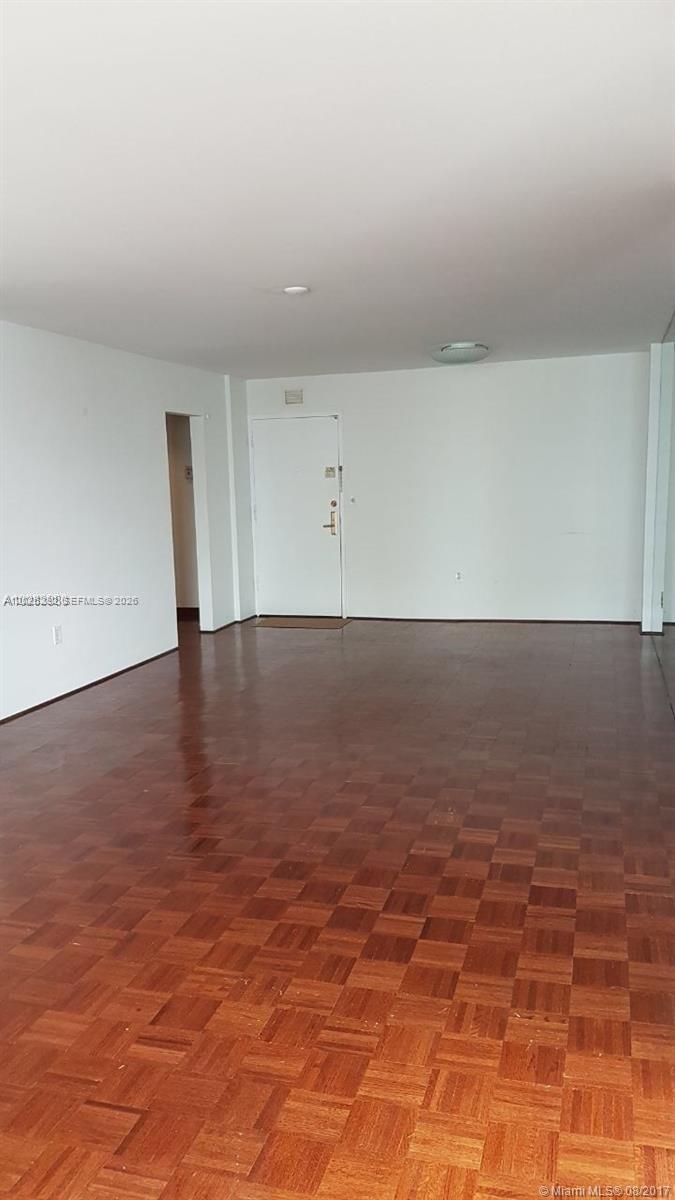 An empty room features white walls and polished parquet wood flooring — 150 SE 25 RD # 15F, Miami FL 33129, MIAMI, FL