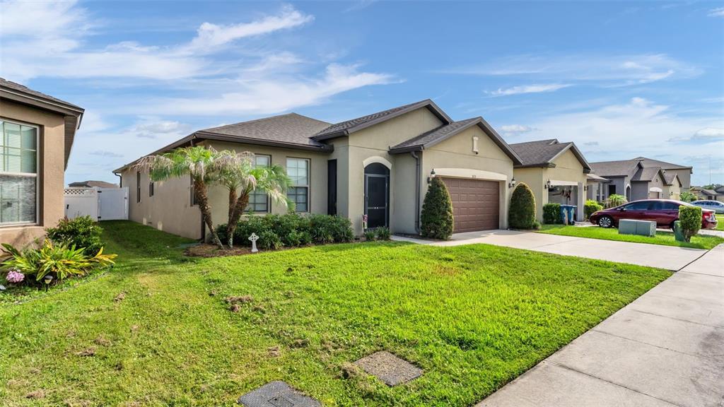 A single-story suburban house with a brown garage, tan stucco exterior, and a front lawn — 8615 RINDGE ROAD, POLK CITY, FL