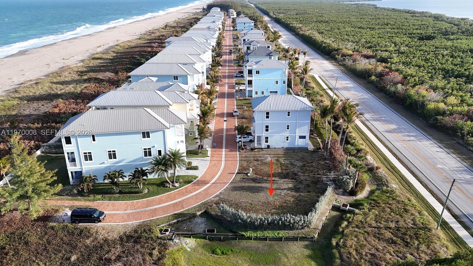 An aerial view shows a vacant coastal lot situated between a residential street and road — 4801 Watersong Way, Fort Pierce FL 34949, FORT PIERCE, FL