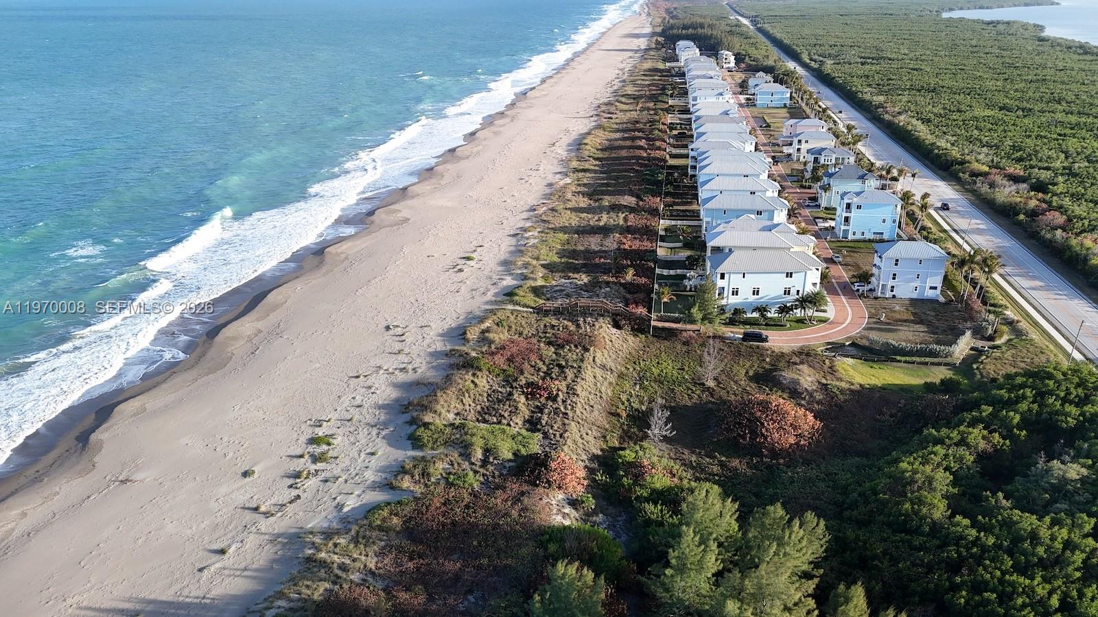An aerial view shows a row of coastal houses situated between a beach and a road — 4801 Watersong Way, Fort Pierce FL 34949, FORT PIERCE, FL