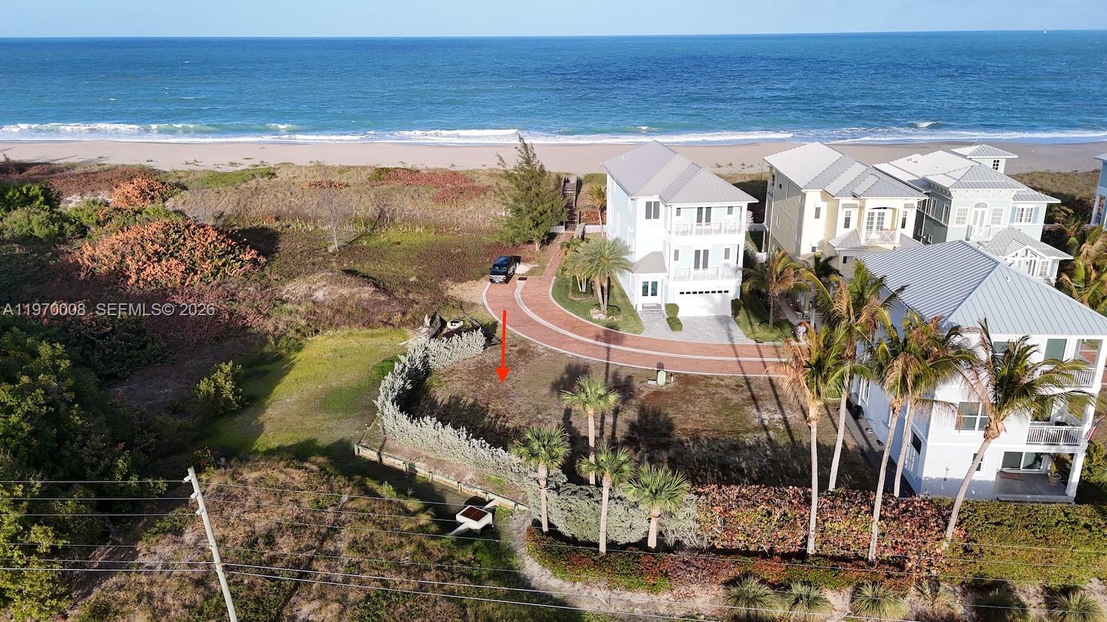 An aerial view shows a vacant coastal lot next to a house near the ocean — 4801 Watersong Way, Fort Pierce FL 34949, FORT PIERCE, FL