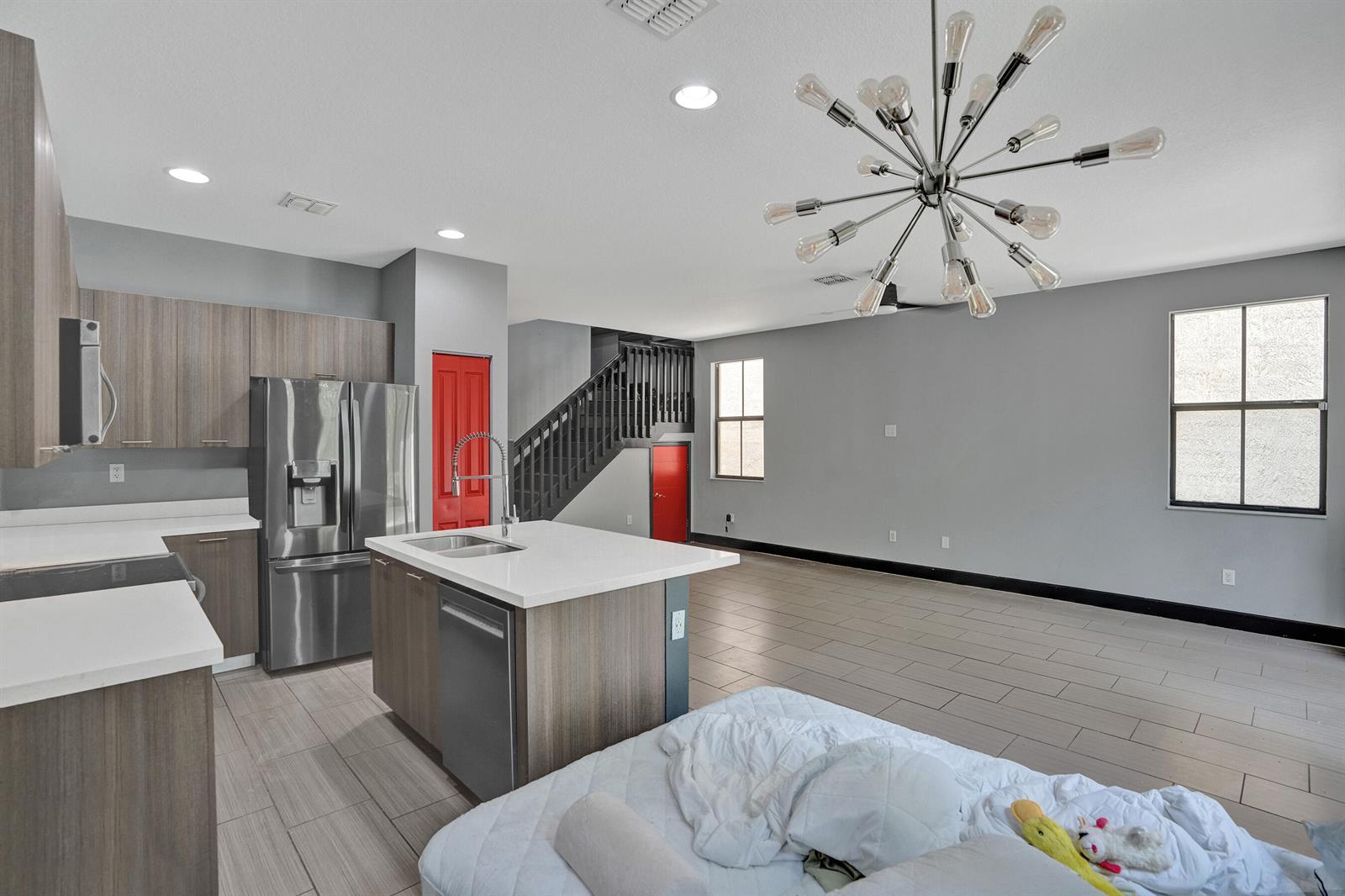 A kitchen with a central island, stainless steel appliances, and gray walls opens to a living area — 5902 NW 46th Lane, Tamarac FL 33319, TAMARAC, FL