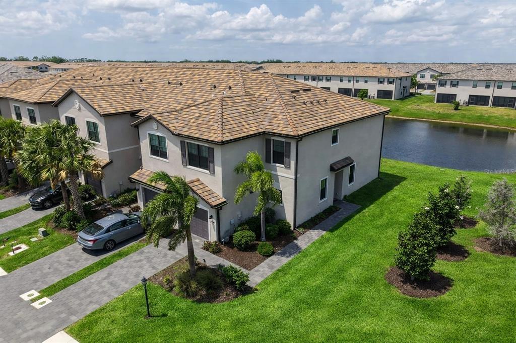 An aerial view of a two-story townhouse with a tiled roof and a paved driveway — 15245 LYLA TERRACE, LAKEWOOD RANCH, FL