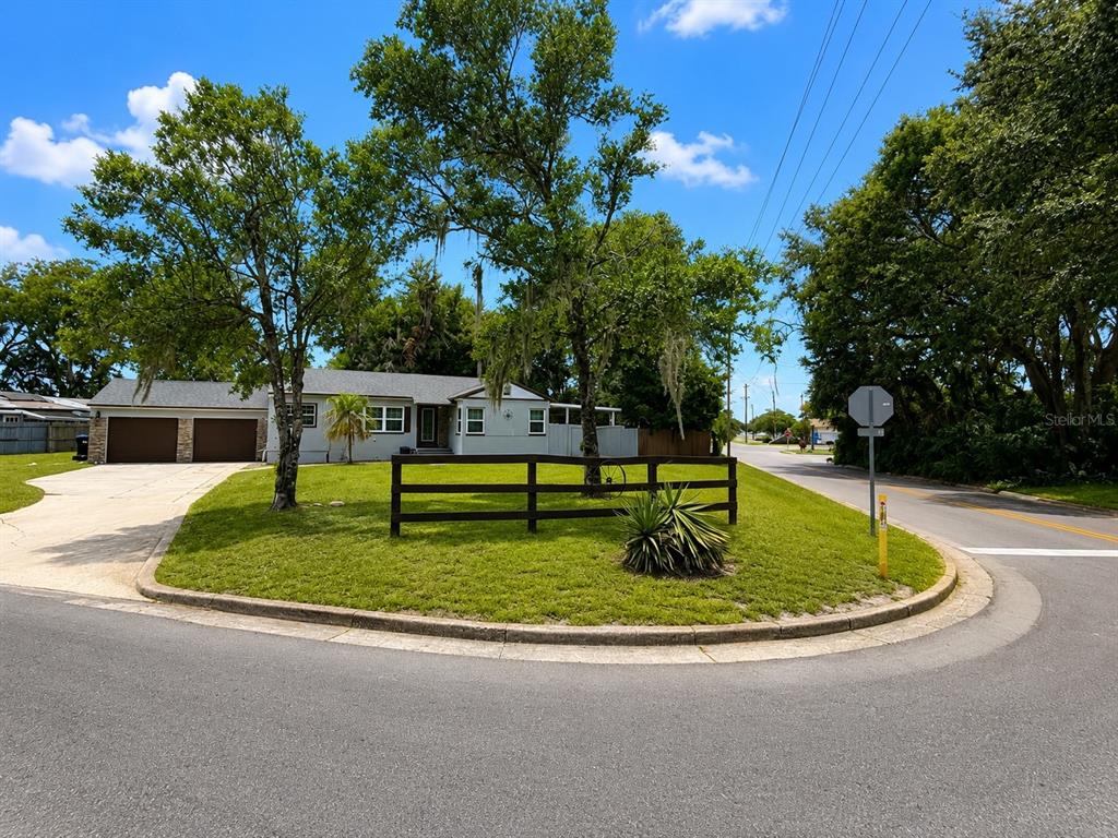 A single-story house with a two-car garage sits behind a wooden fence and lawn — 2400 S LAUREL AVENUE, SANFORD, FL