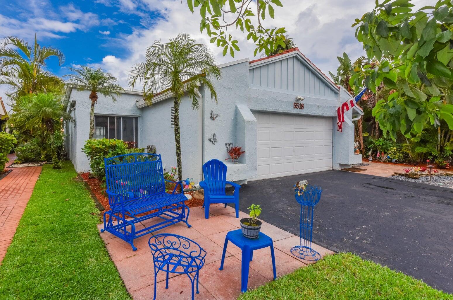 A light blue house with a garage, a paved driveway, and blue patio furniture outside — 5518 Ainsley Court, Boynton Beach FL 33437, BOYNTON BEACH, FL