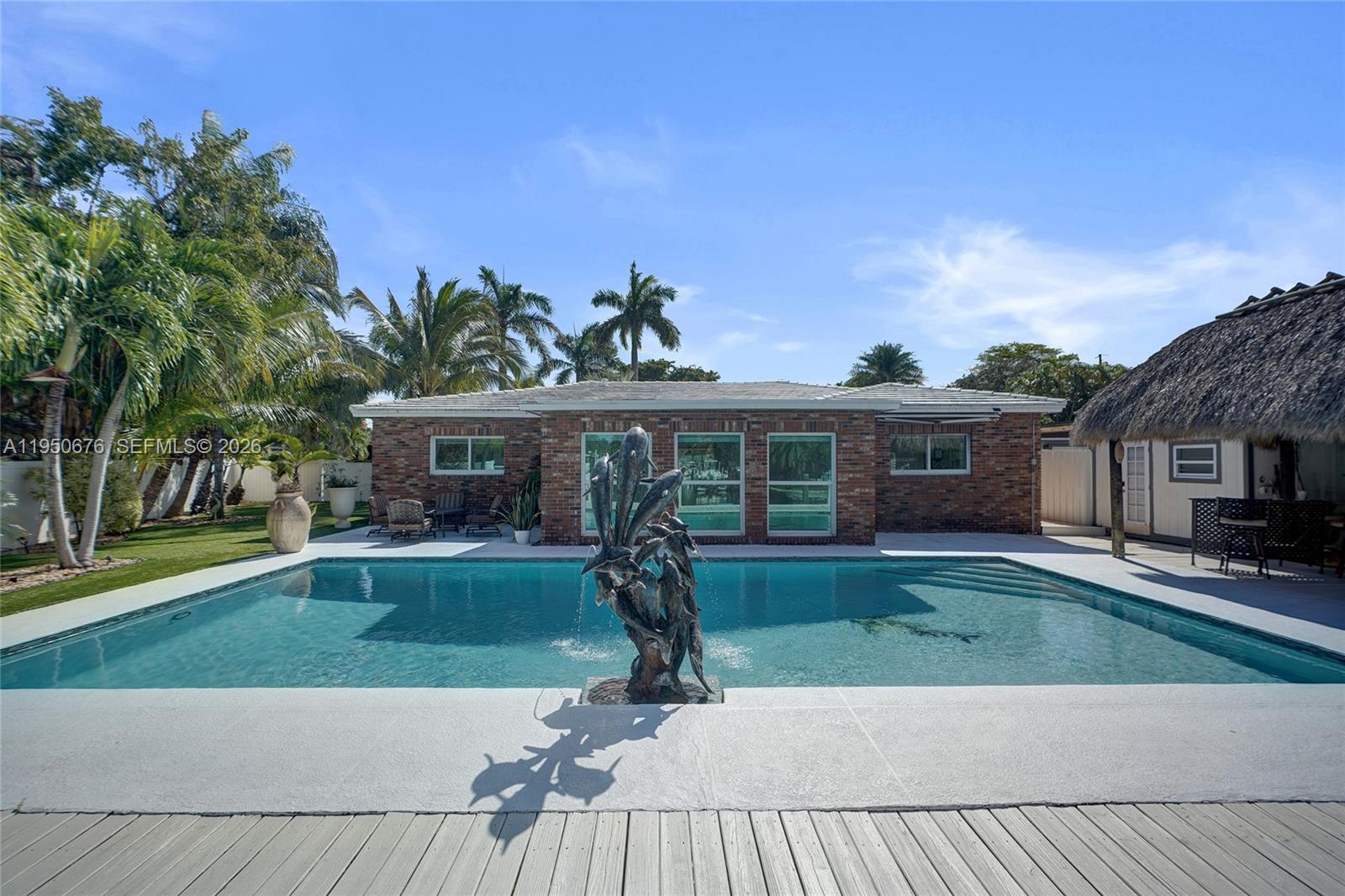 A brick house with a swimming pool and a central fish fountain in the backyard — 1995 N Hibiscus Dr, North Miami FL 33181, NORTH MIAMI, FL