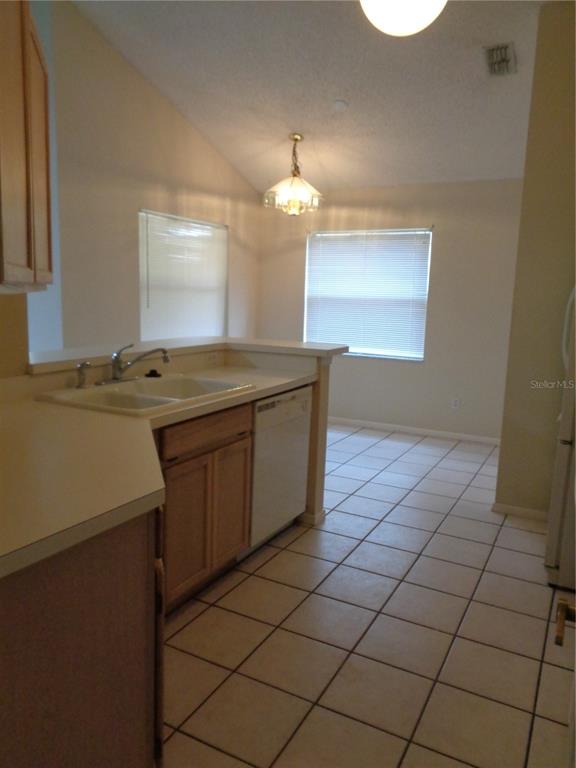 A kitchen with light-colored tile floors, wooden cabinets, and a double sink — 2125 RIVER PARK BOULEVARD, ORLANDO, FL