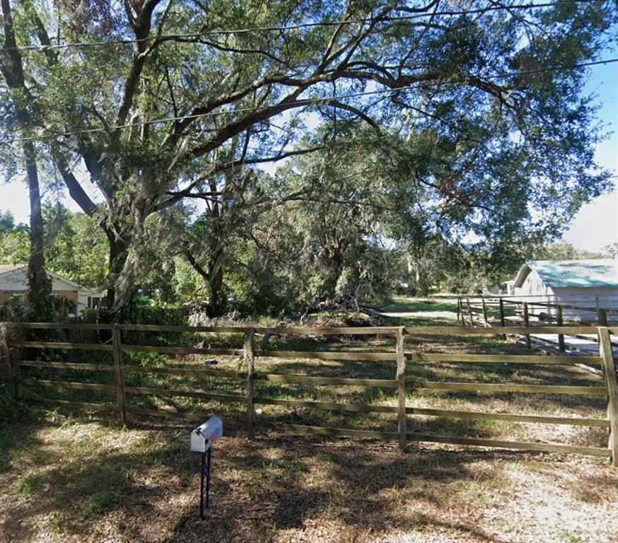A wooden fence encloses a wooded lot with a mailbox in the foreground — S CHURCH AVENUE S, FORT MEADE, FL