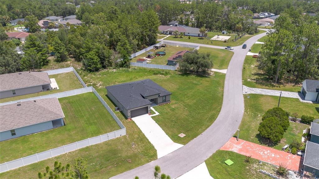 An aerial view shows a single-story house with a dark roof and a concrete driveway — 15690 SW 49TH AVENUE ROAD, OCALA, FL