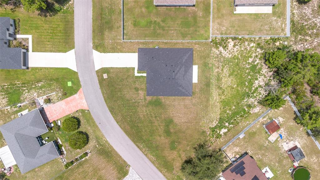 An aerial view shows a single-family home with a dark roof on a grassy lot — 15690 SW 49TH AVENUE ROAD, OCALA, FL