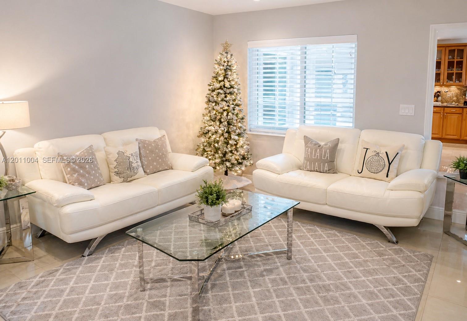 A living room features two white leather sofas, a glass coffee table, and a Christmas tree — 10290 SW 24th Ct, Miramar FL 33025, MIRAMAR, FL