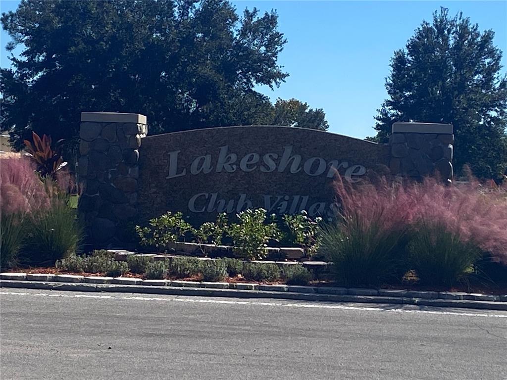 A stone monument sign for Lakeshore Club Villas stands behind pink ornamental grasses — 4409 CLUB CIRCLE, LAKE WALES, FL