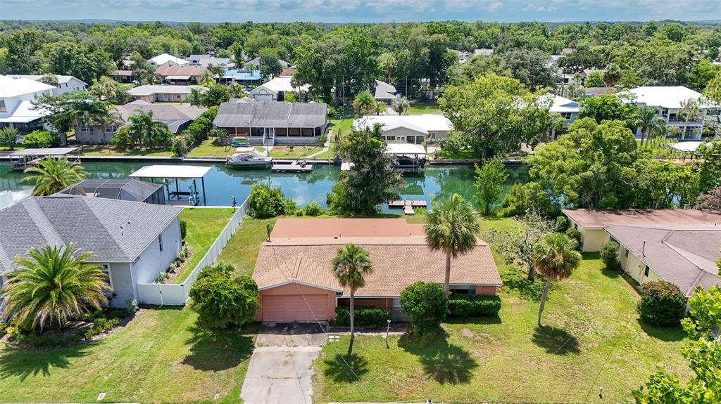 An aerial view shows a single-story house with a brown roof beside a canal — 1201 SE PARADISE AVENUE, CRYSTAL RIVER, FL