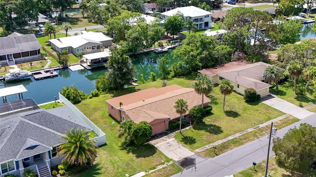 An aerial view shows a residential neighborhood with houses along a canal and a street — 1201 SE PARADISE AVENUE, CRYSTAL RIVER, FL