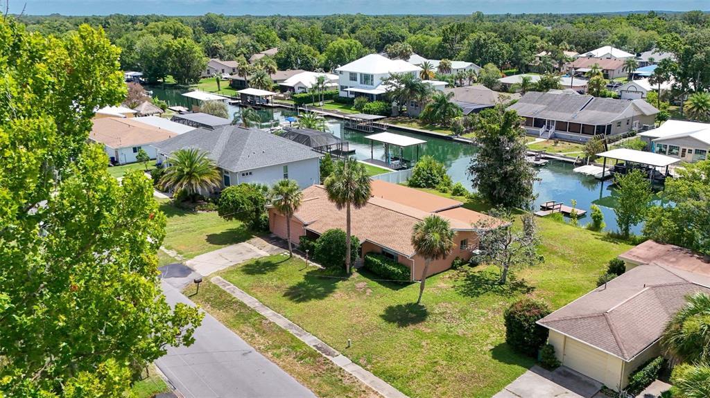 An aerial view shows a residential neighborhood with houses along a canal and boat docks — 1201 SE PARADISE AVENUE, CRYSTAL RIVER, FL