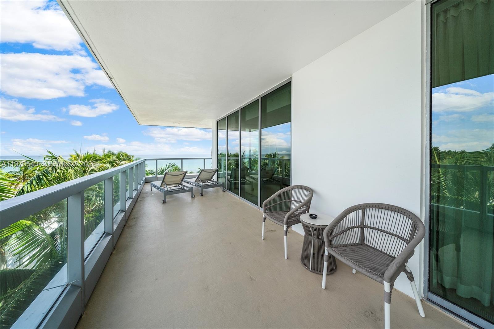 A balcony with two lounge chairs, two patio chairs, and a small table overlooking the ocean — 4391 Collins Ave # 410, Miami Beach FL 33140, MIAMI BEACH, FL