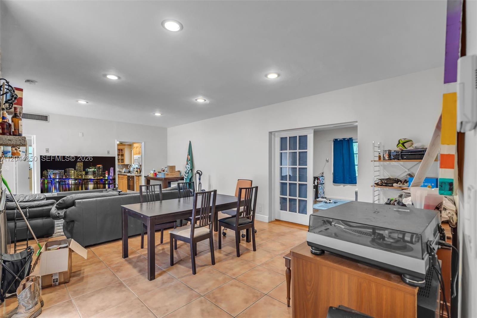 A living and dining area with tile floors, recessed lighting, and a dark wood table — 1439 Miller Rd, Coral Gables FL 33146, CORAL GABLES, FL