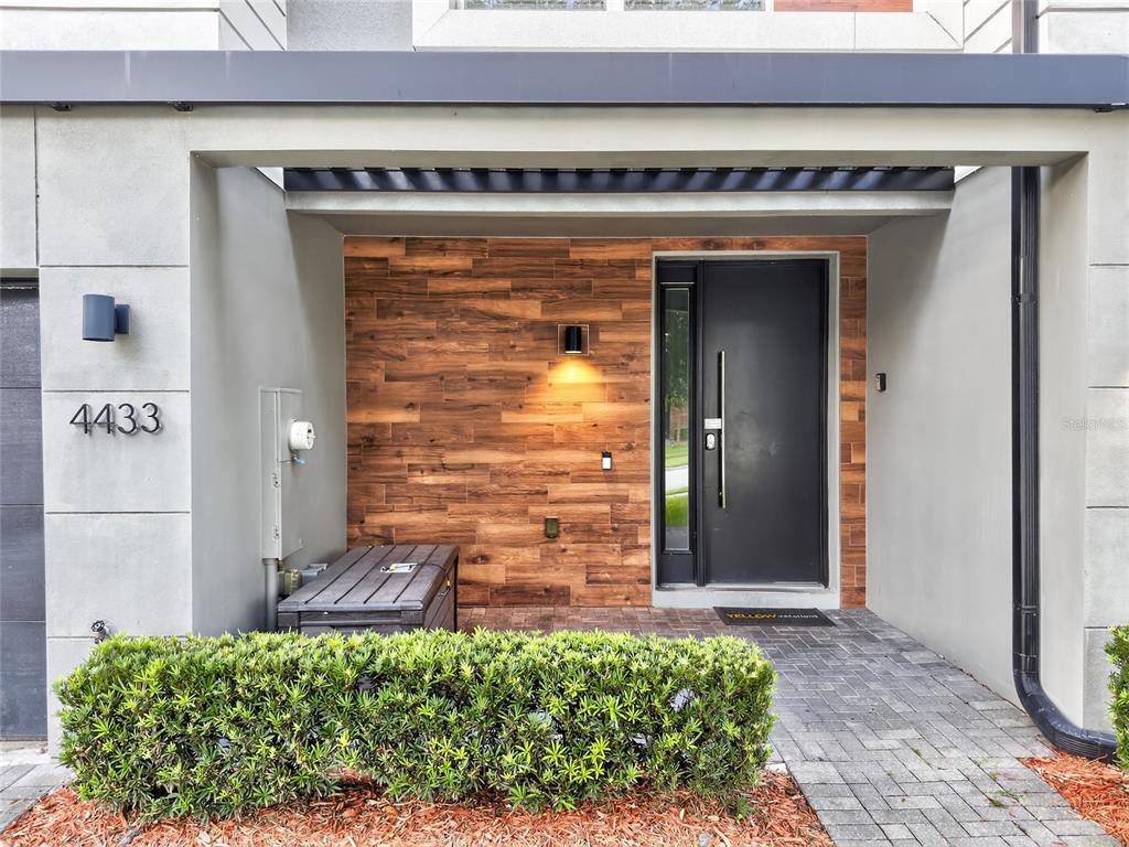 The exterior entrance features a dark door, wood-look wall paneling, and a paved walkway — 4433 LE REVE COURT, KISSIMMEE, FL